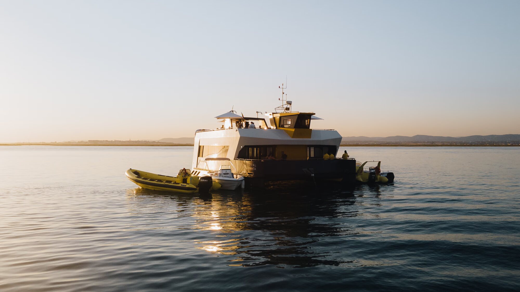 De catamaran op het water van Ria Formosa bij zonsondergang