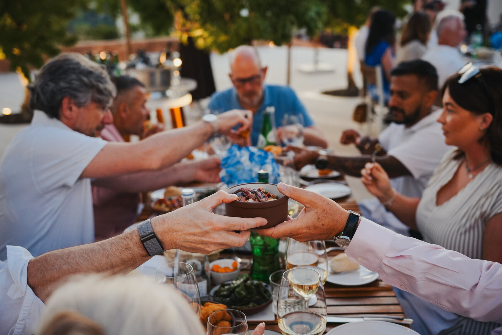 Gasten delen gerechten aan een lange tafel