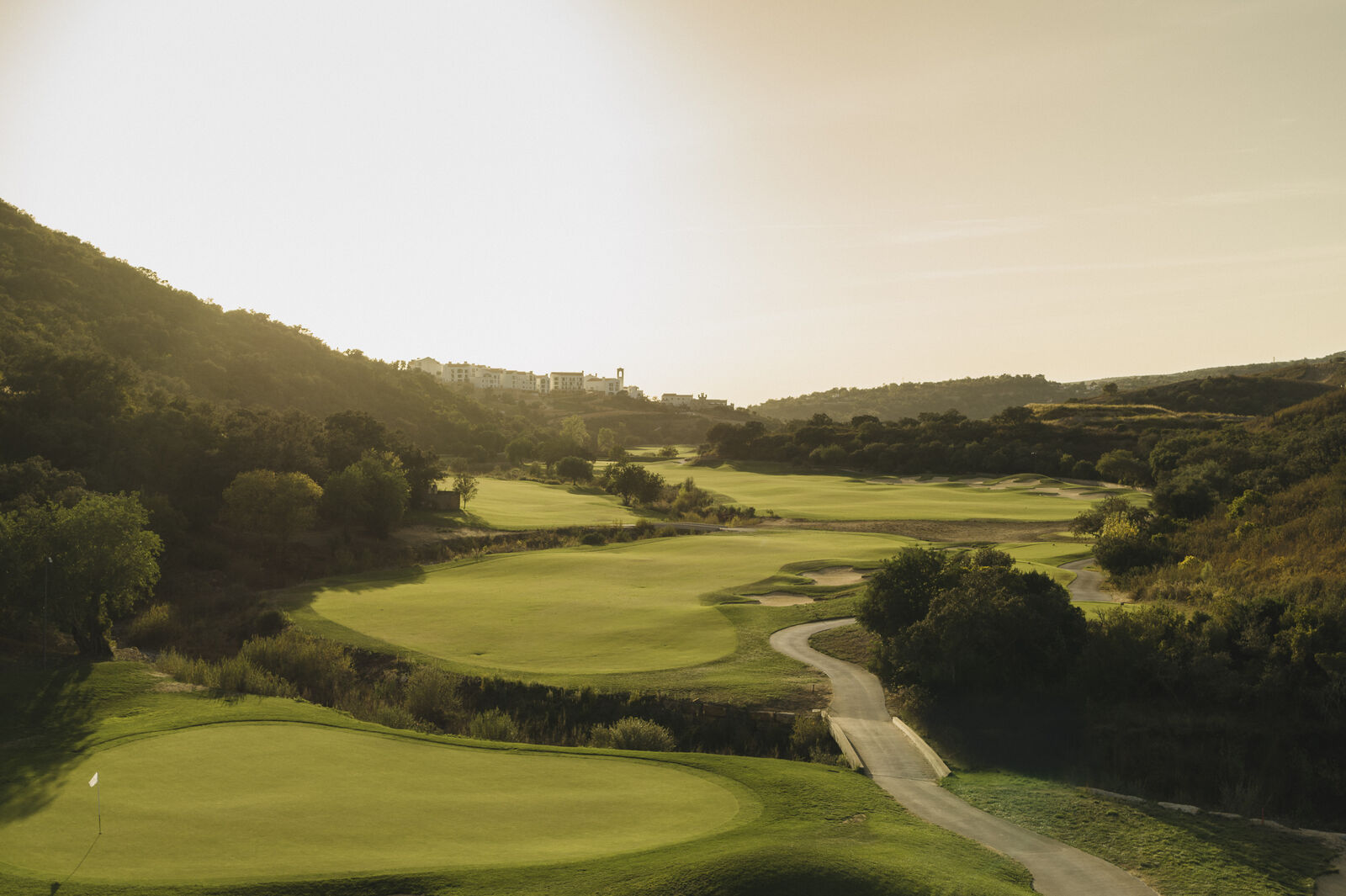Fairways in het dal met het resort op de heuvel