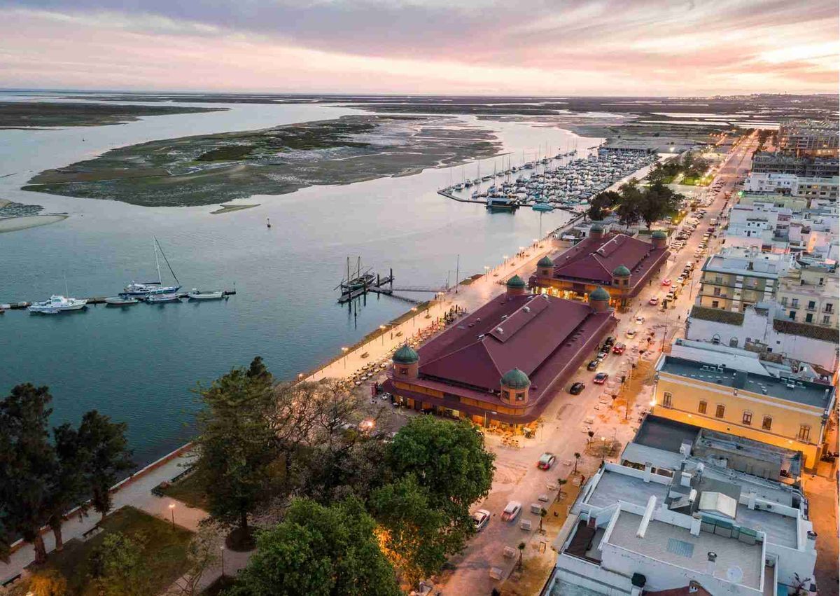 Olhão bij zonsondergang, met de markthallen, de jachthaven en Ria Formosa